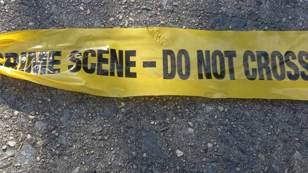 Yellow crime scene do not cross tape on pavement