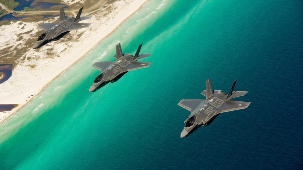 Three U.S. Air Force F-35A Lightning II jets flying in formation over the Florida coast